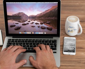 Image of laptop with coffee mug and iPhone